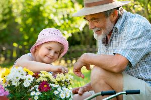 grief-support-man-helping-child-tend-flowers-in-garden