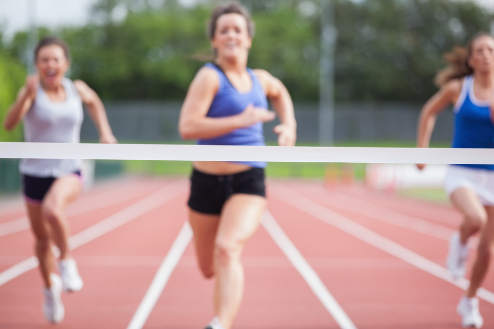 athletes approach finish line at track field